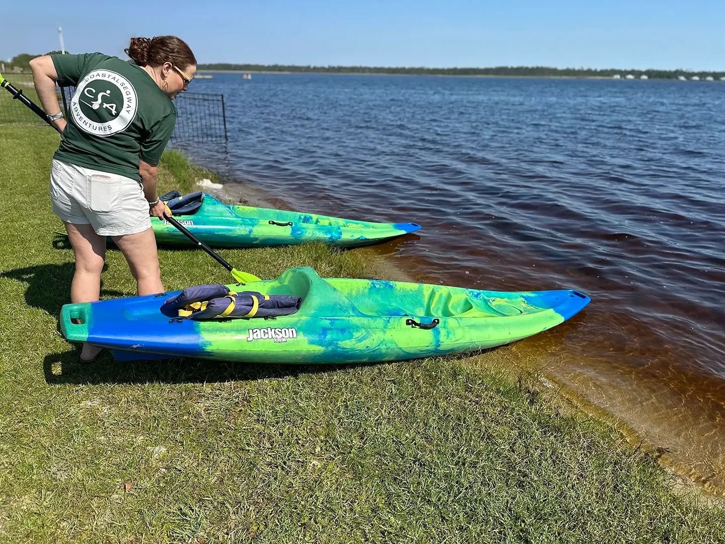 Guide preparing kayaks at waterside